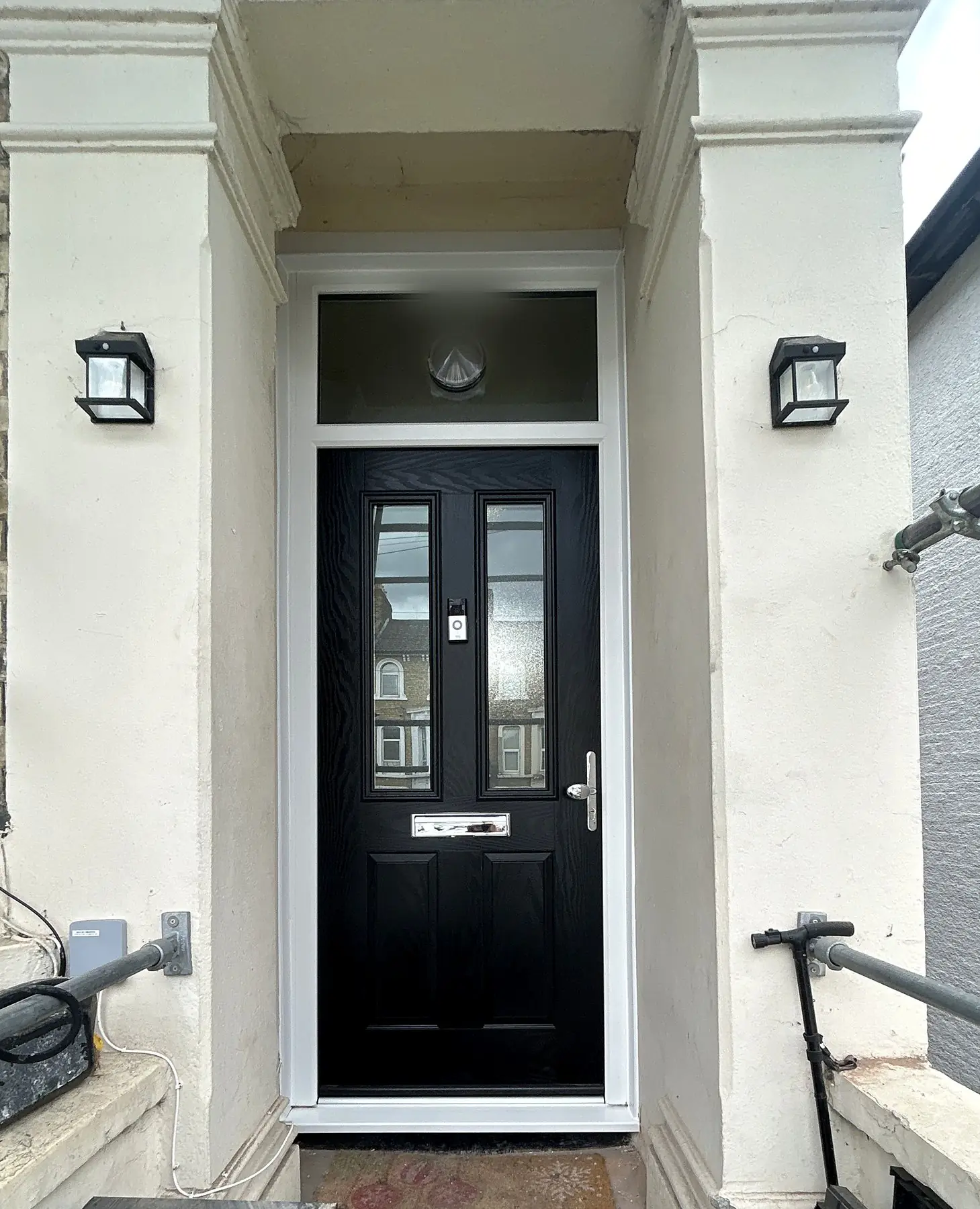 Black composite front door in a Victorian porch